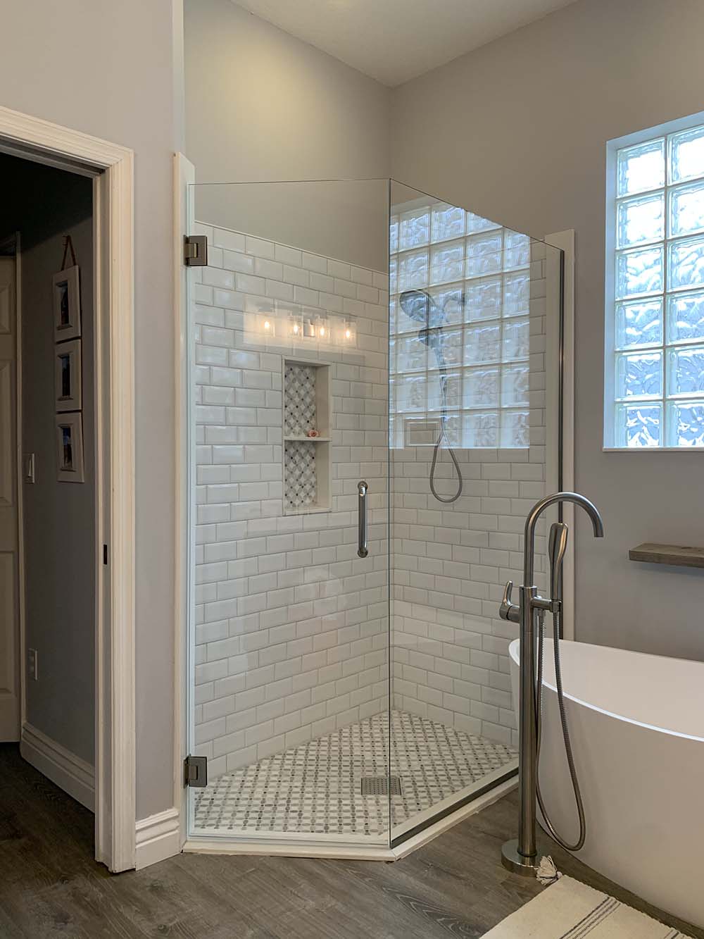 Frameless glass shower enclosure with angled panels