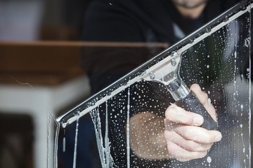 Using a squeegee to clean a shower door